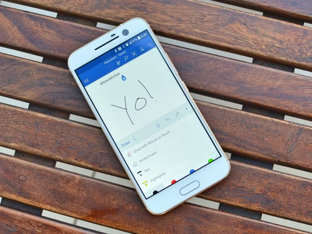 Móvil sobre mesa mostrando mensaje 'Yo!' en pantalla.